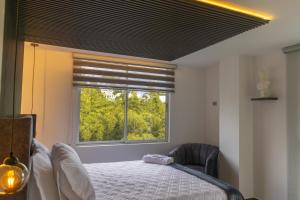 锡卡西亚Piso en el Quindío, apartamento de lujo的带床和窗户的卧室