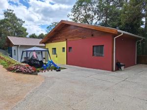 una piccola casa con un parco giochi di fronte di Chalé Acácia - Recanto Veky a Campos do Jordão