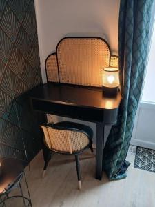 a desk with a lamp and a chair with a candle at Petite maison studio cosy avec jardin in Saint-Honoré-les-Bains +12 photos