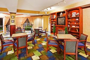 una sala da pranzo con tavoli, sedie e TV di Holiday Inn Express & Suites Kings Mountain - Shelby Area, an IHG Hotel a Kings Mountain