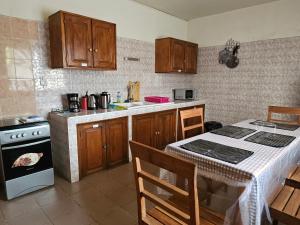 a kitchen with wooden cabinets and a table and a stove at Villa duchesse in Sali Nianiaral