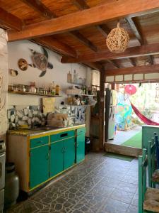 a kitchen with green cabinets and a refrigerator at Wiracocha Hostal Máncora in Máncora