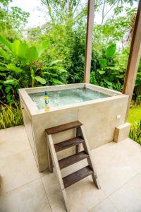 a hot tub with a ladder next to a stool at Tortuga Premium Riverfront Jungle Villa with Jacuzzi and Pool in Uvita