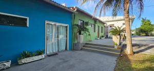 マナウスにあるVila Boulevard Aconcheganteのヤシの木が目の前に広がる青緑の家