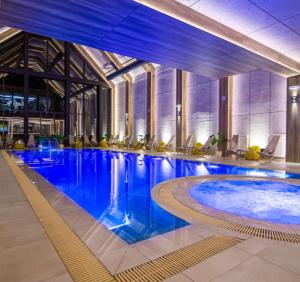 ズラティボールにあるJazz apartman Titova vilaの建物内の青い水の大きなプール +19枚の写真