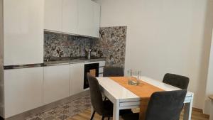 a kitchen with a table and chairs and a kitchen with white cabinets at Appartamenti Rocchesi in Rocca San Felice +45 photos