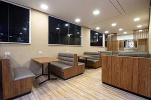 圣保罗Hotel Age - Próximo Arena Corinthians e Aeroporto de Guarulhos的一间设有长椅和桌子的等候室,以及窗户
