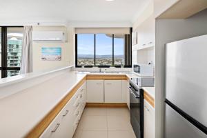 a kitchen with white cabinets and a large window at Oceanfront 24th Floor 1 Bedroom Retreat with Stunning Views & Free Parking in Gold Coast