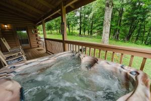 a jacuzzi tub on the deck of a cabin at A Dream Come True cabin in Sevierville