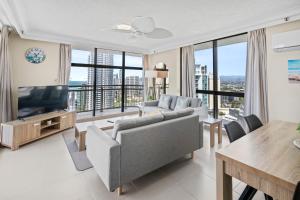 a living room with a couch and a television at Oceanfront 24th Floor 1 Bedroom Retreat with Stunning Views & Free Parking in Gold Coast