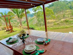 a table with plates and glasses on top of it at Chalé Belmont - Santa Teresa in Santa Teresa