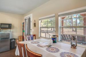 a dining room with a table and two windows at Plantersville Cabin on 50 Acres with Pond and Fire Pit in Magnolia