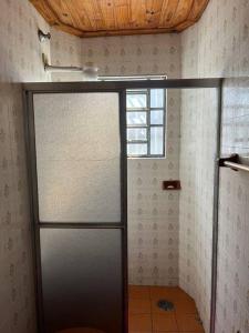 a bathroom with a shower with a glass door at Apartamento Itaguá in Ubatuba