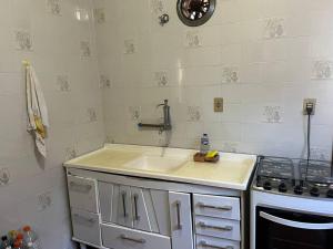 a kitchen with a sink and a stove at Apartamento Itaguá in Ubatuba