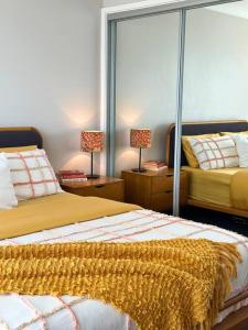 - une chambre avec 2 lits et 2 lampes sur les tables dans l'établissement Casa Dis Family Friendly 350m walk to beach, à Caves Beach