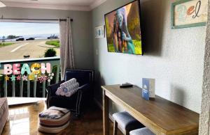 a living room with a table and a balcony at Beachfront View Condo at Casa Del Mar in Galveston