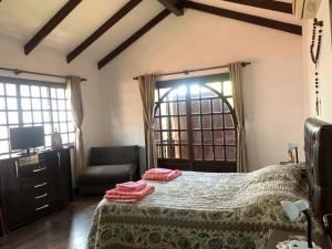 a bedroom with a bed and a chair and a television at The House Of Don Lucho in Santa Cruz de la Sierra