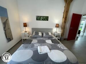 ein Schlafzimmer mit einem großen Bett mit zwei Nachttischen in der Unterkunft Gîte rénové avec spa, piscine chauffée, WiFi et accès handicapés au cœur du Marais Breton - FR-1-426-321 in Soullans