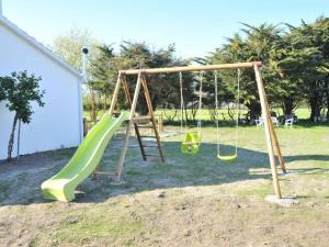 einen Spielplatz mit zwei Schaukeln und einer Rutsche in der Unterkunft Gîte rénové avec spa, piscine chauffée, WiFi et accès handicapés au cœur du Marais Breton - FR-1-426-321 in Soullans