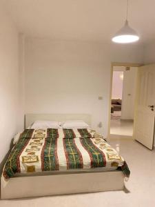 a bedroom with a bed in a white room at Cozy House In Gardenia, Nasr city, Center in Cairo