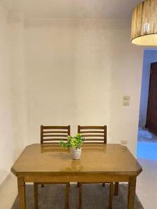 a wooden table with two chairs and a potted plant at Cozy House In Gardenia, Nasr city, Center in Cairo