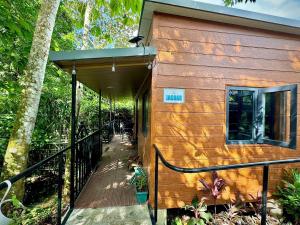 eine Holzhütte mit Veranda und Balkon in der Unterkunft Bungalows at Residencias Arenal in Fortuna