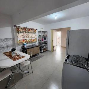a large kitchen with a table and a refrigerator at Espaço Tranquilo-preço até 4 hóspedes in Pôrto Feliz