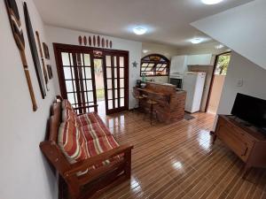 a living room with a couch and a kitchen at Casa Becker - Praia Seca in Araruama