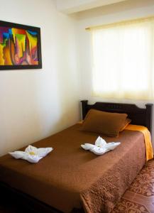 a bedroom with a bed with two towels on it at Hotel Quinchia in Quinchía