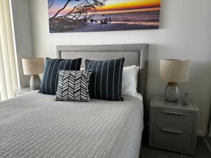 a bedroom with a bed with pillows and a painting on the wall at Broadwater Parklands Paradise in Gold Coast +43 photos