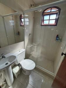 a bathroom with a toilet and a shower and a sink at Casa Becker - Praia Seca in Araruama +28 photos