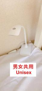 a white lamp sitting on top of a bed at HOSTEL198 bunk bed For UnisexーVacation STAY68108v in Osaka