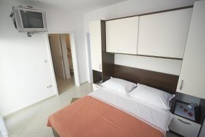 a bedroom with a bed and a tv in it at Apartments Rubic in Omiš