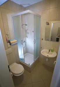 een badkamer met een douche, een toilet en een wastafel bij Apartments Rubic in Omiš
