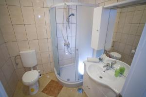 a bathroom with a shower and a toilet and a sink at Apartments Rubic in Omiš