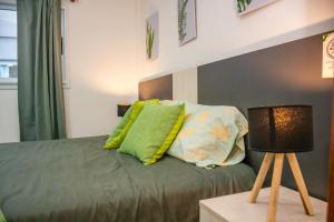 ein Bett mit grünen und weißen Kissen und einer Lampe in der Unterkunft Centro Apart Home in Jesús María