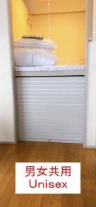 una puerta de garaje con una cama encima en HOSTEL198 Unisex dormitory cabin typeーVacation STAY68082v, en Osaka