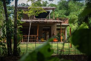 una casa con una valla delante en CASA RAÍZ RÍO ANCHO, en Mingueo