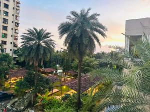 达曼Areca Palms Hotel & Resort的建筑物前的一组棕榈树