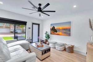 フォート・ローダーデールにあるLovely 2BR 2BA Modern Flat with Vibrant Backyardのリビングルーム(白いソファ、天井ファン付)