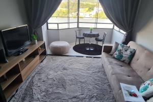 a living room with a couch and a tv and a table at Pensado por um turista, pra você in Serra Negra