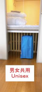 Una maleta azul debajo de una cama en una habitación. en HOSTEL198 Unisex dormitory cabin typeーVacation STAY68082v, en Osaka 5 fotos más