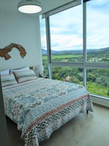 a bedroom with a bed and a large window at Beachfront Apt with optional cook and airport pickup in Nueva Gorgona +50 photos