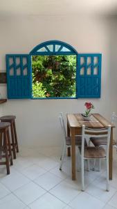 a dining room with a table and a blue window at Villa Mahai- casa 1 in Cayru