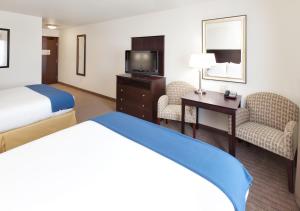 Habitación de hotel con cama, escritorio y TV. en Holiday Inn Express & Suites - Omaha I - 80, an IHG Hotel en Gretna