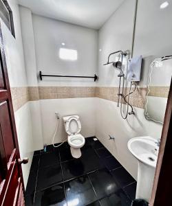 a bathroom with a toilet and a sink at Domon Riverside Hotel in Vang Vieng