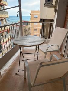 Una mesa y sillas en un balcón con vista al mar. en Coastal Charm in Alicante, en Alicante