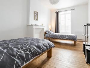 a bedroom with two beds and a window at Maison rénovée avec wifi, centre bourg de St Mars la Jaille - FR-1-306-1289 in Vallons-de-l'Erdre
