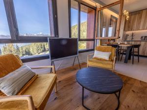 a living room with a tv and chairs and a table at Appartement neuf avec terrasse, SPA et parking inclus - 6 pers - FR-1-352-103 in Arc 1800