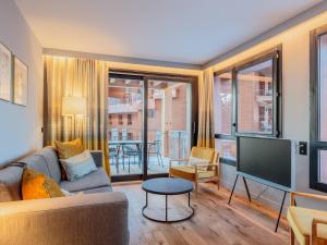 a living room with a couch and a flat screen tv at Appartement neuf avec terrasse, SPA et parking inclus - 6 pers - FR-1-352-103 in Arc 1800